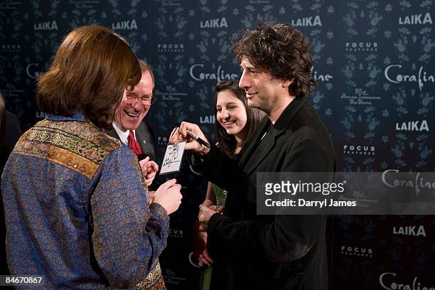Author Neil Gaiman, with his daughter Maddy Gaiman, center signs an autograph for Oregon Governor Ted Kulongoski, center and his niece, at the...