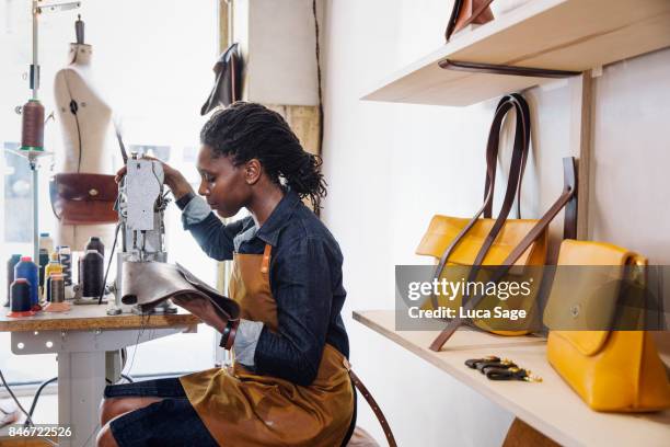 leather handbag store with designer working at her sewing machine - woman sewing bildbanksfoton och bilder