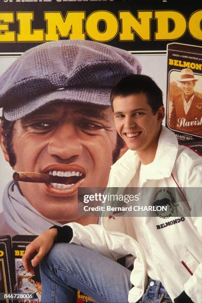 Le coureur automobile Paul Belmondo posant devant une photo de son pere Jean-Paul Belmondole 16 mars 1983 a Paris, France.