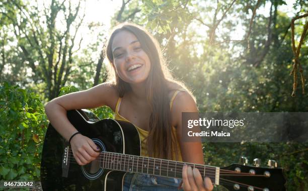 meisje spelen gitaar - guitar stockfoto's en -beelden