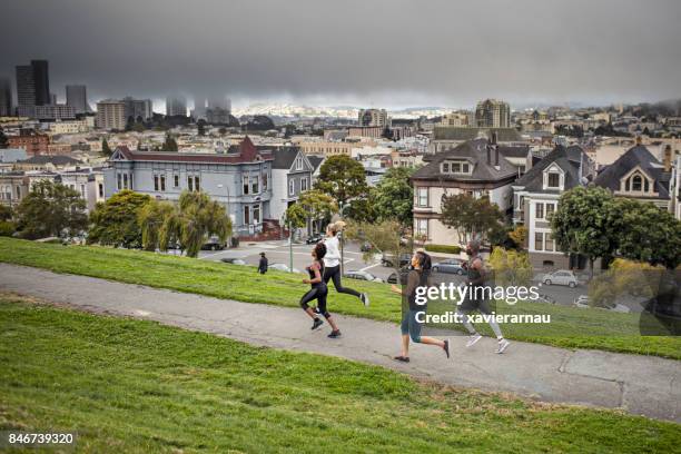 four people running on a park in san francisco - san francisco marathon stock pictures, royalty-free photos & images