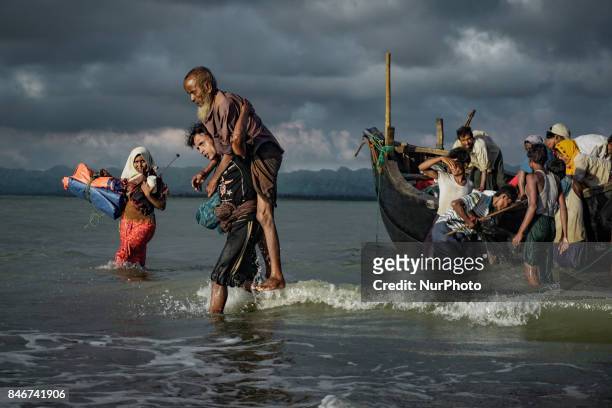 Rohingya Muslim refugees disembark from a boat on the Bangladeshi side of Naf river in Teknaf on September 13, 2017. International divisions emerged...
