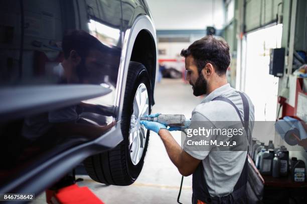 tire changing at car service - replacement stock pictures, royalty-free photos & images