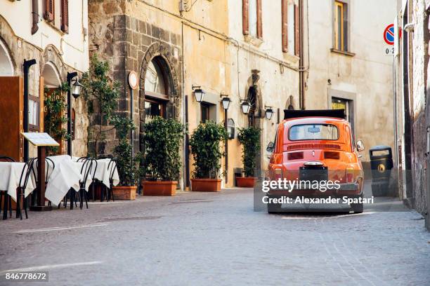 old red vintage car on the narrow street in italy - street cafe stockfoto's en -beelden