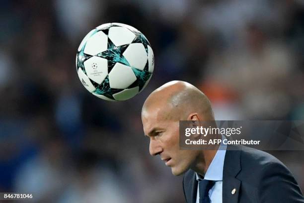 Ball passes above Real Madrid's French coach Zinedine Zidane during the UEFA Champions League football match Real Madrid CF vs APOEL FC at the...