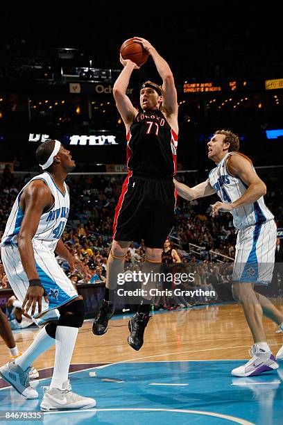 Jake Voskuhl of the Toronto Raptors makes a shot over James Posey and Sean Marks of the New Orleans Hornets on February 6, 2009 in New Orleans,...