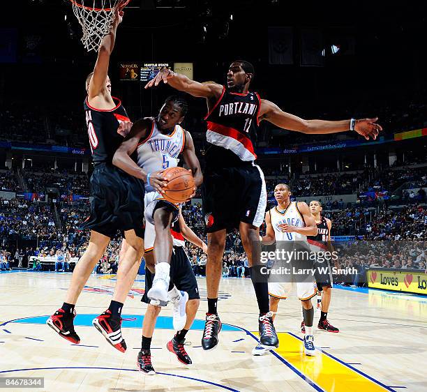 Kyle Weaver of the Oklahoma City Thunder goes to the basket against Joel Przybilla and LaMarcus Aldridge of the Portland Trail Blazers at the Ford...