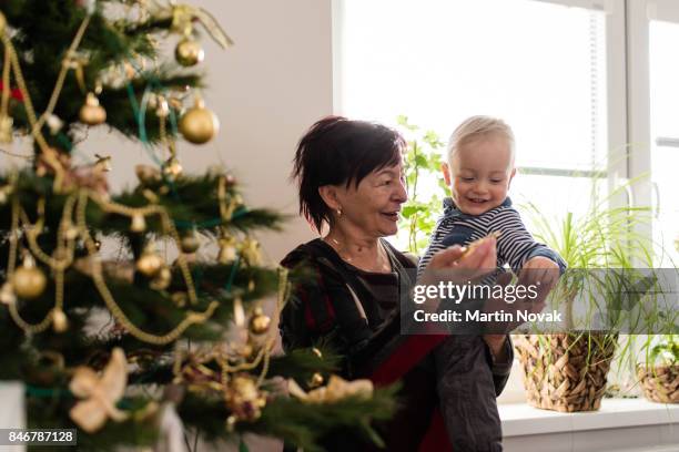 playful grandson in arms of his grandmother - winter baby stockfoto's en -beelden