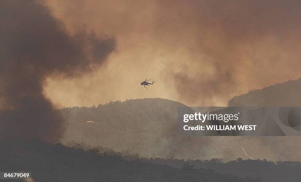 Fire-fighting helicopter approaches an out of control fire in the Bunyip State Park near Labertouche, some 125 kilometres west of Melbourne, on...