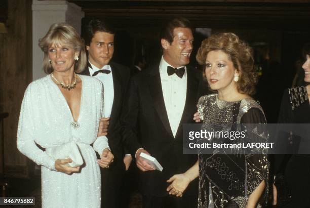 Linda Evans en compagnie de Roger Moore et son epouse Luisa arrivent a une soiree Van Cleef Et Arpels le 28 decembre 1983 a Gstaad, Suisse.