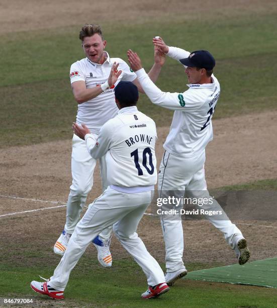 Sam Cook of Essex celebrates with team mates after taking the wicket of Ian Bell during the Specsavers County Championship Division One match between...