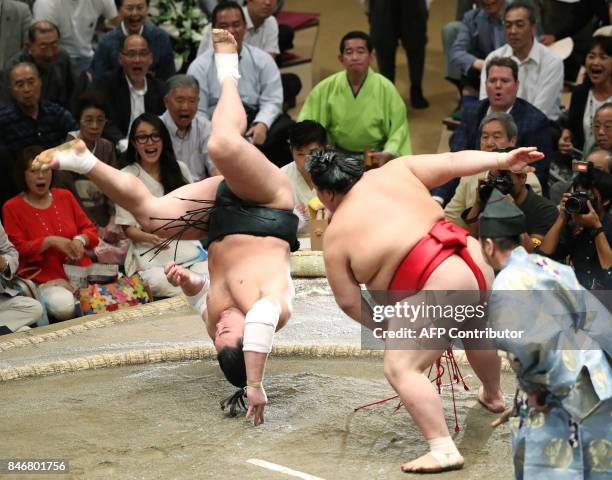 Grand sumo champion, or "yokozuna", Harumafuji of Mongolia somersaults over to lose his bout against Onosho of Japan on the fifth day of the 15-day...