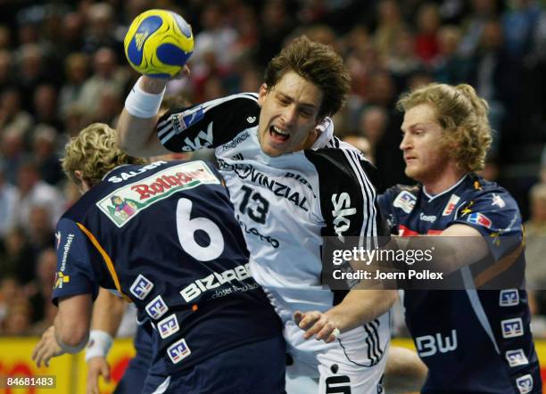 Marcus Ahlm of Kiel and Felix Lobedank and Daniel Sauer of Balingen compete for the ball during the Handball Bundesliga match between THW Kiel and...