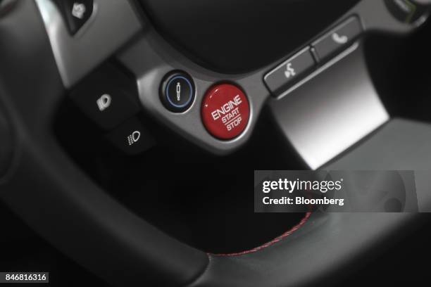 An engine start and stop button sits on the steering wheel of a Ferrari NV Portofino entry-level supercar during the second media preview day of the...