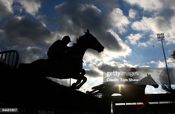 Riders jump a fence during the williamhill.com Play Poker Graduation Steeple Chase during the race meeting at Kempton Racecourse on February 7, 2009...