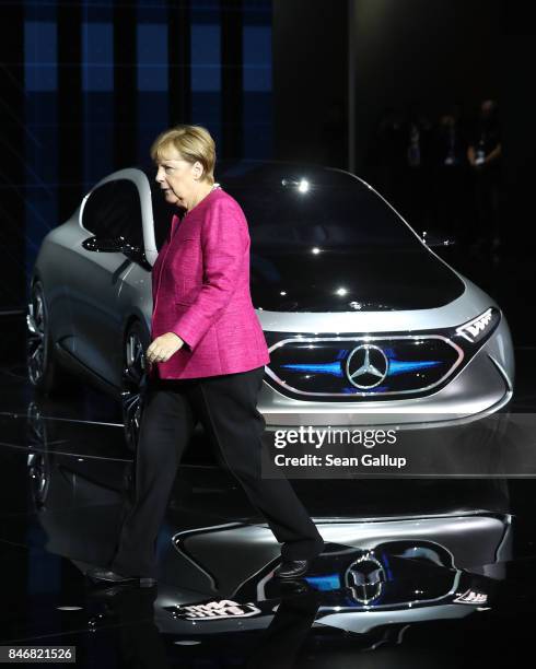 German Chancellor Angela Merkel walks past a Mercedes Concept EQA electric car while visiting the Mercedes hall at the 2017 IAA Frankfurt Auto Show...