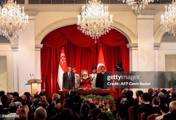 President-elect Halimah Yacob takes the oath of office while flanked by Singapore Prime Minister Lee Hsien Loong and Chief Justice Sundaresh Menon...