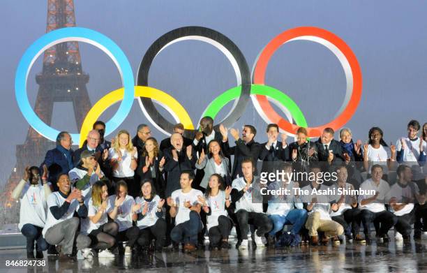 Volunteers pose after the unveiling of the Olympic rings on the esplanade of Trocadero in front of the Eiffel tower after the official announcement...