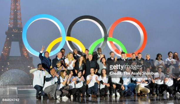 Volunteers pose after the unveiling of the Olympic rings on the esplanade of Trocadero in front of the Eiffel tower after the official announcement...
