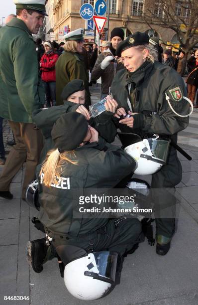 Police woman hurt by pepper spray is medicated by colleagues during a demonstration against the Munich Security Conference and the NATO policy on...