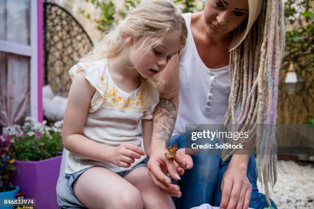 mother holding butterflies with her daughter - releasing butterfly stock pictures, royalty-free photos & images