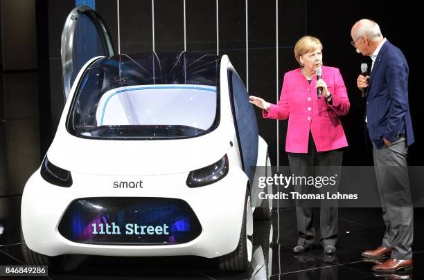 Dieter Zetsche, Chairman of Daimler AG, shows the German Chancellor Angela Merkel a Smart Vision EQ concept car during her visit at the 2017...