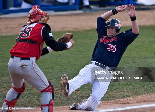 Jackson Melian of Tigres de Aragua of Venezuela slides safe in to home base as catcher Eli Marrero of Leones de Ponce of Puerto Rico tries to stop...