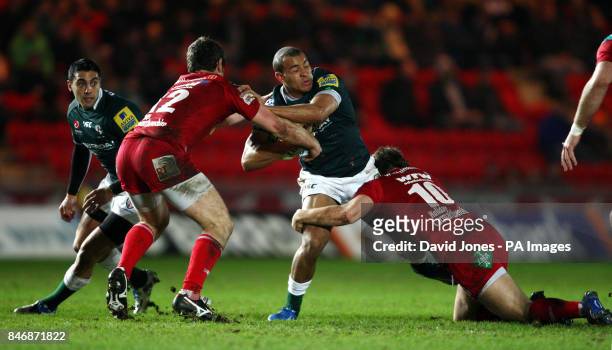 London Irish's Jonathan Joseph is tackled by Llanelli Scarlets' Adam Warren and Aled Thomas during the LV=Cup match at Parc Y Scarlets, Llanelli.