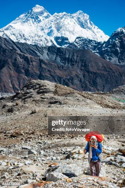 mountaineer with heavy pack hiking below mt everest himalayas nepal - gokyo valley stock pictures, royalty-free photos & images