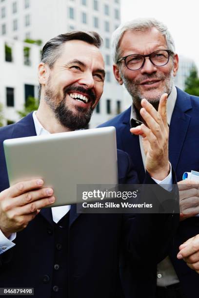 portraits of two businessmen standing in front of a modern apartment building - mann anzug gebäude objekt draussen stock-fotos und bilder