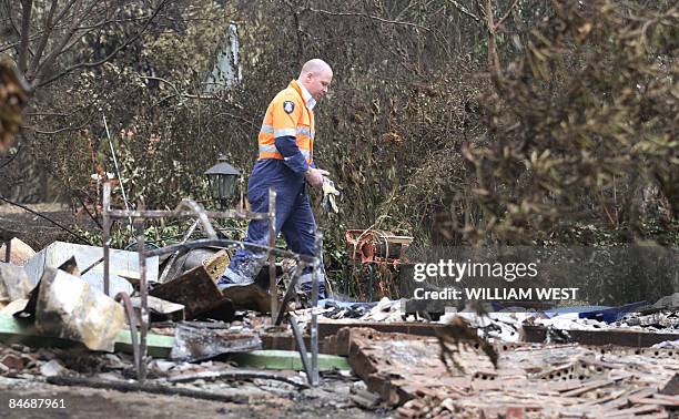 Policeman looks over a house where five people died at Kinglake, north of Melbourne, on February 8, 2009. At least 65 people were killed and entire...