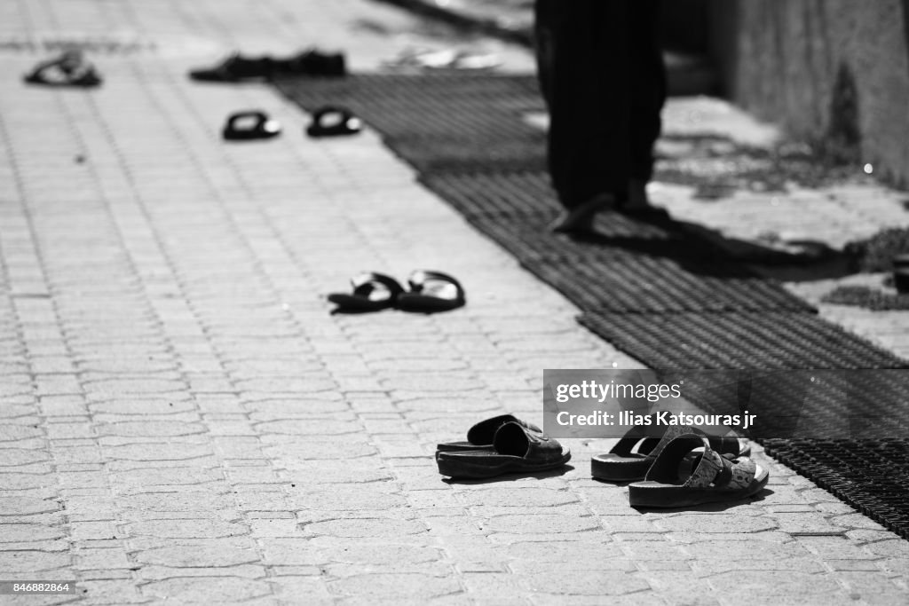 Man walks barefoot after leaving shoes outside mosque in Al Seeb, Muscat, Oman