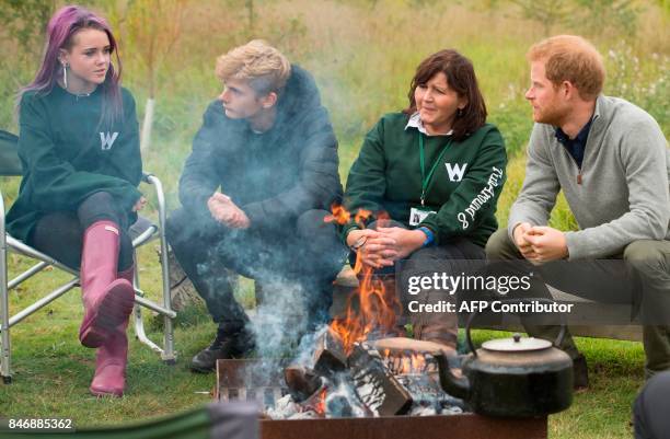 Britain's Prince Harry reacts as he talks with recent graduates from the Wilderness Foundation's TurnAround programme during his visit to Chatham...