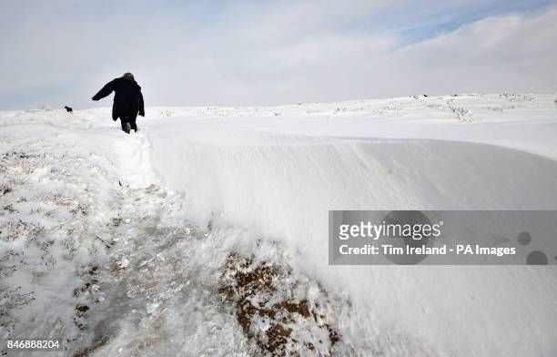 Woman negotiates deep snow on Dunkery Hill on Exmoor in Somerset as the cold weather continues across the UK.