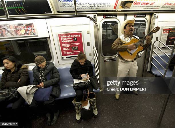 Guitar player plays for passengers on a northbound numer 6 train January 30, 2009 in New York. Scores, perhaps hundreds, of freelance musicians...