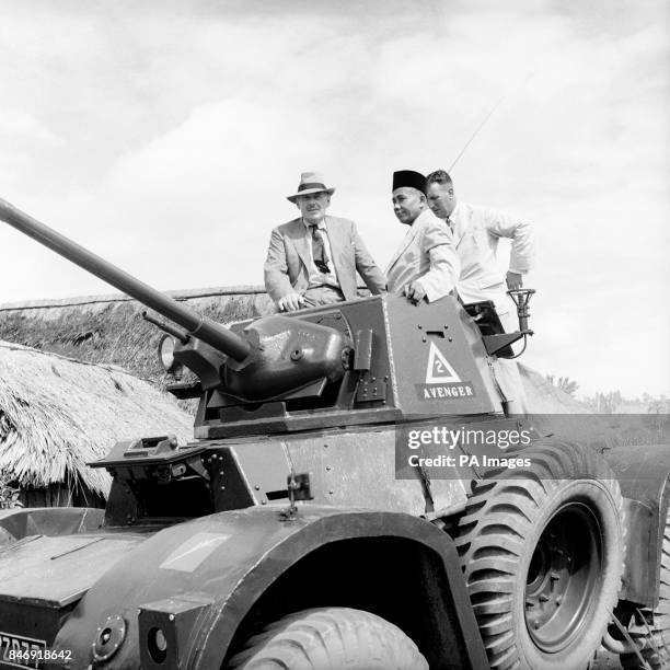 Seated in the turret of a Daimler Armoured Car, Mr Oliver Lyttelton, Colonial Secretary visits a resettlement area in Johore during his tour of...