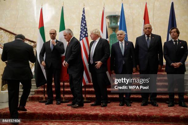 In his capacity as host, Britain's Foreign Secretary Boris Johnson, fourth left, gets ready to pose for a group photograph with, from left, UAE's...