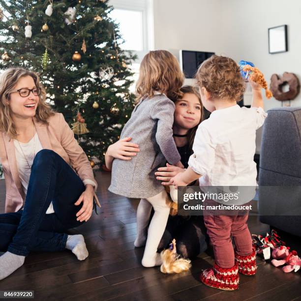 opening gifts on christmas morning for small family. - cousin stock pictures, royalty-free photos & images