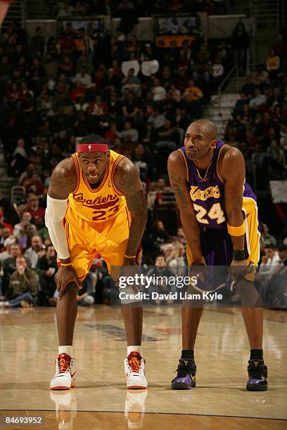 LeBron James of the Cleveland Cavaliers crouches besides Kobe Bryant of the Los Angeles Lakers during a break in the action at The Quicken Loans...