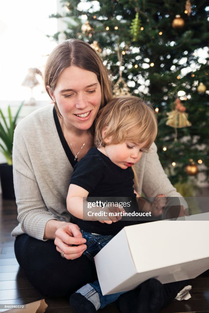 Opening gifts on Christmas morning for mother and son.