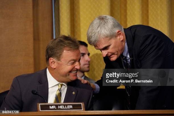 Sen. Dean Heller speaks with Sen. Bill Cassidy during a tax reform hearing before the Senate Finance Committee on Capitol Hill September 14, 2017 in...