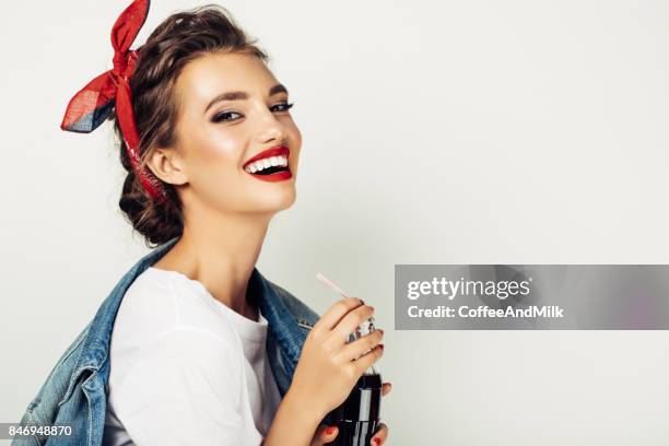 young elegant female drinking cola - coca cola jeans stock pictures, royalty-free photos & images