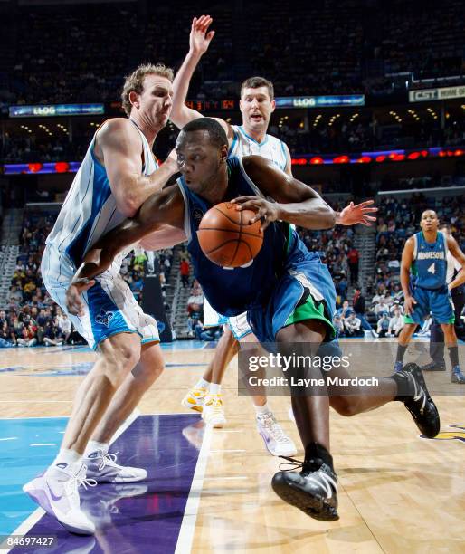 Al Jefferson of the Minnesota Timberwolves drives past Sean Marks and Ryan Bowen of the New Orleans Hornets on February 8, 2009 at the New Orleans...