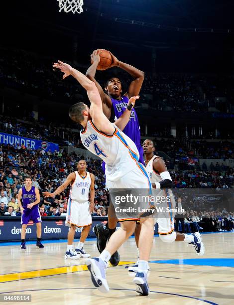 Jason Thompson of the Sacramento Kings goes to the basket against Nick Collison of the Oklahoma City Thunder at the Ford Center on February 8, 2009...