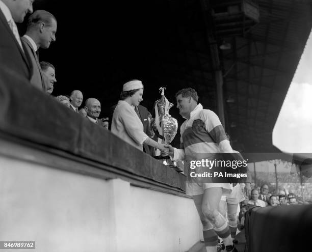 Queen Elizabeth II presents the Rugby League Challenge Cup to Derek Turner, captain of Wakefield Trinity, after she had watched, with 80,000 other...