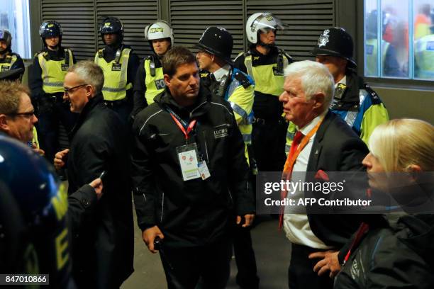 Cologne's President Werner Spinner speaks to officials outside the stadium as police guard the entrances as the kick off is delayed due to crowd...