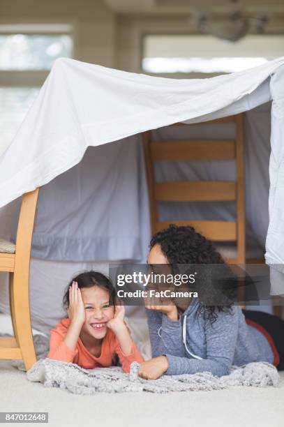 young ethnic mom and daughter laying on living room floor and talking about life - kids fort stock pictures, royalty-free photos & images