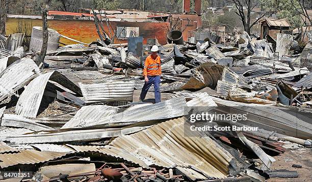 Man surveys the remains of a property after a bushfire swept through it on February 9, 2009 in Bendigo, 160 km north of Melbourne, Australia. Eight...