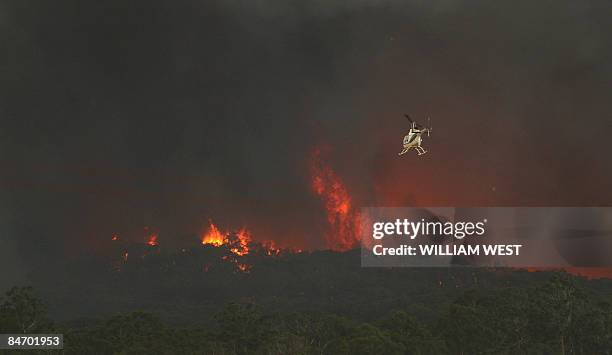 Fire-fighting helicopter approaches an out of control fire in the Bunyip State Park near Labertouche, some 125 kilometres west of Melbourne, on...