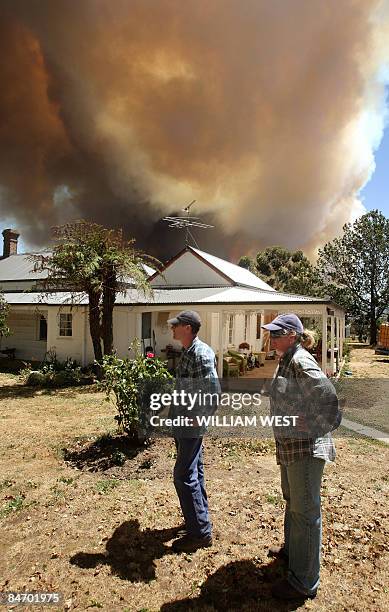 Farming couple monitor a giant fire raging in the Bunyip State Park near Labertouche, some 125 kilometres west of Melbourne, on February 7, 2009....